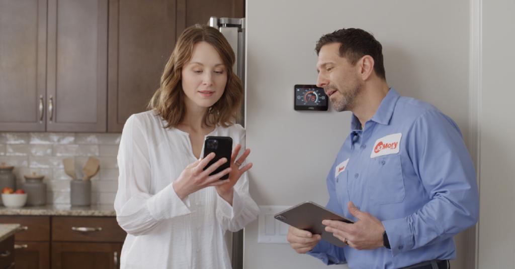 female homeowner standing next to male contractor looking at cell phone