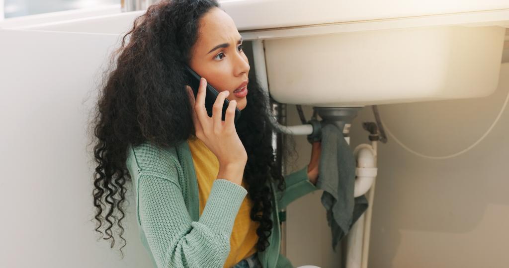 Woman making phone call about under sink plumbing link